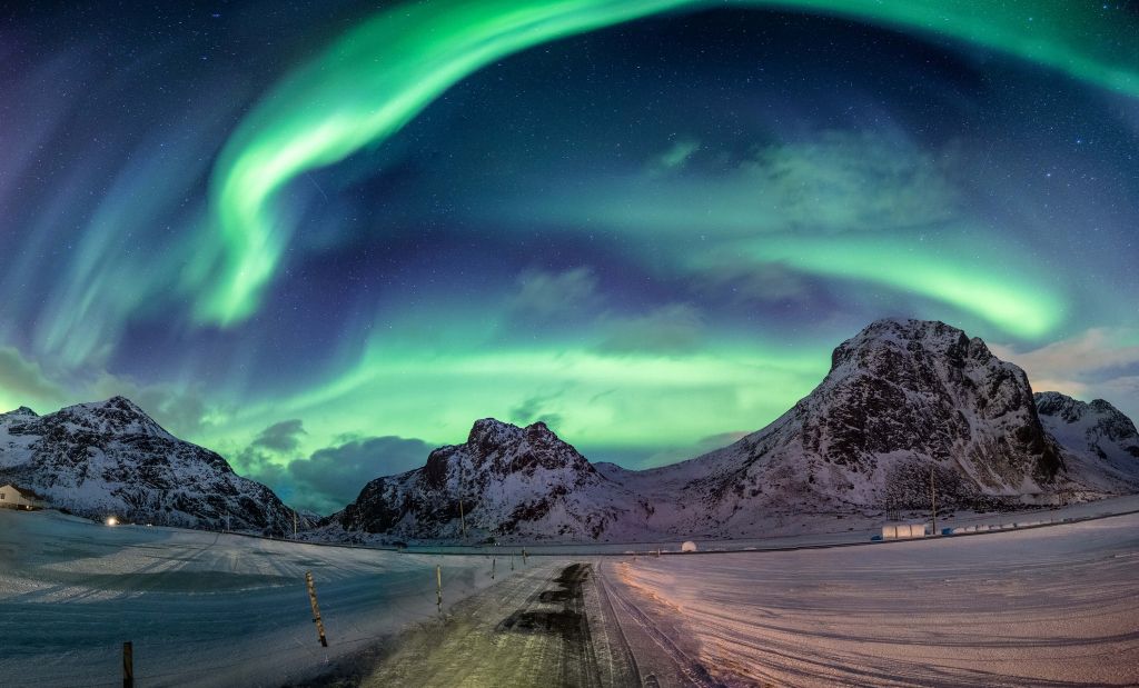 Nordlicht über verschneiten Bergen